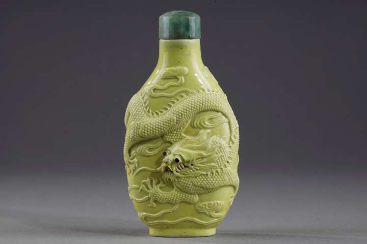 Snuff bottle porcelain enamelled yellow molded and sculpted with a dragon